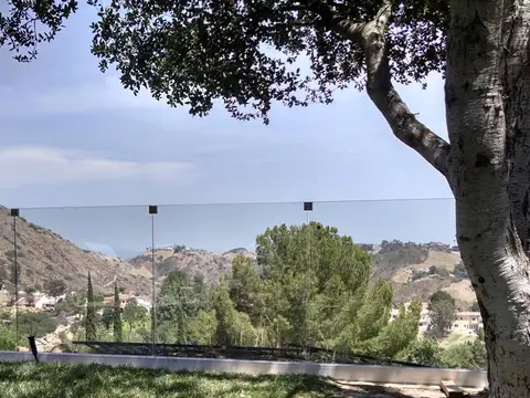 Frameless glass terrace railing overlooking the hills