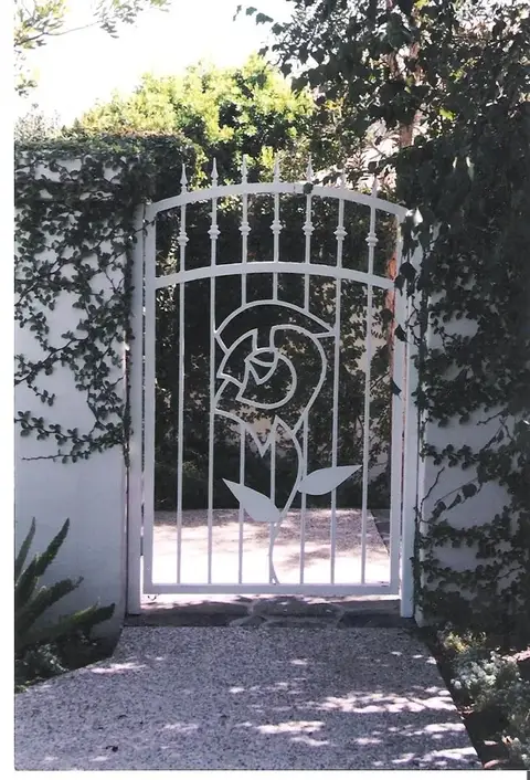 White garden gate with a rose silhouette design
