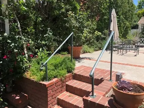 Brick garden steps with simple iron handrails