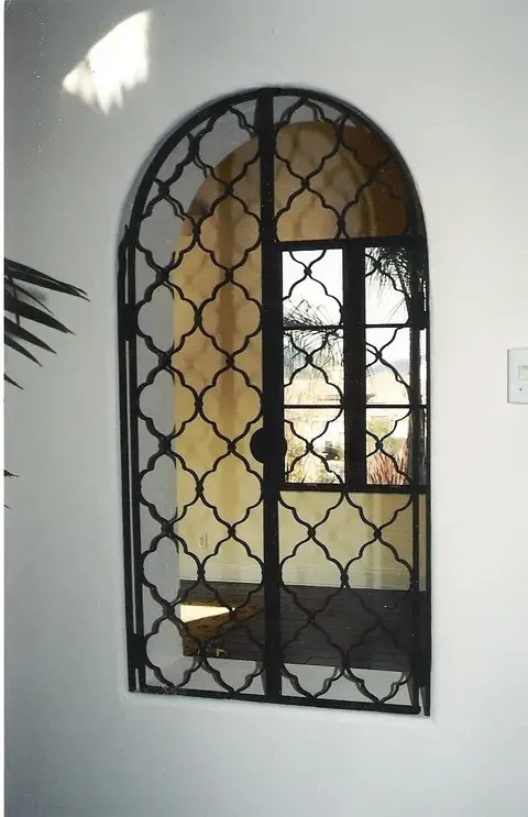 Arched window grille with a quatrefoil lattice pattern