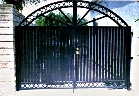 Arched double driveway gates with circle details and a sunburst top