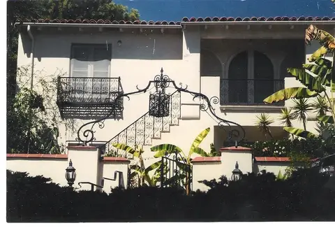 Exterior staircase railing and Juliet balcony on a Spanish-style home