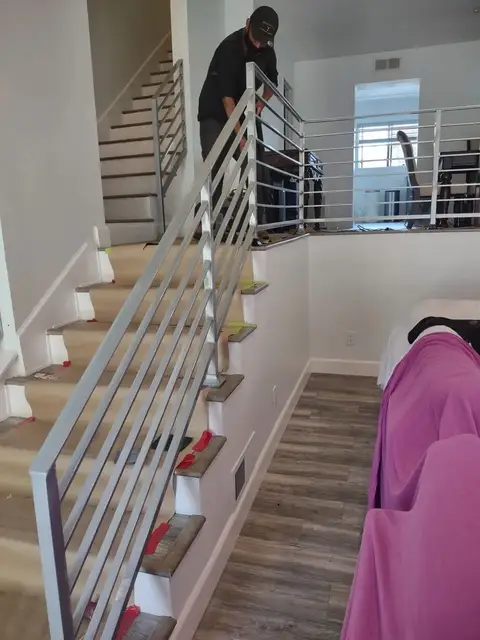 Modern horizontal-bar stair railing during installation