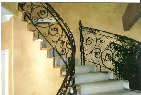 Curved staircase railing with flowing scrollwork on both sides