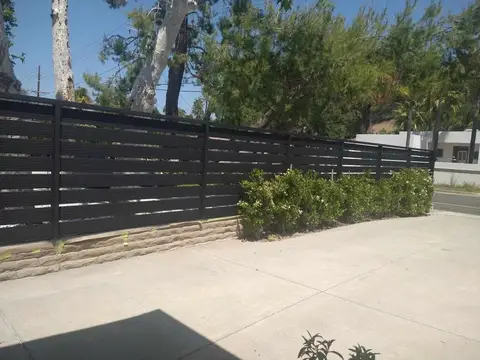 Long horizontal slat privacy fence along a driveway