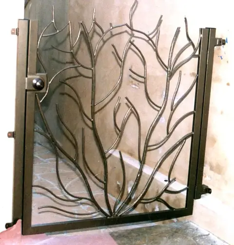 Pedestrian gate with a hand-forged flame and branch design