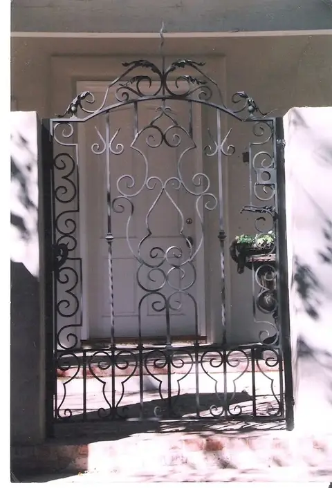 Ornate entry gate with a crown scroll top and heart details