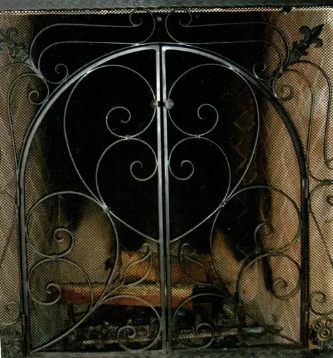 Arched fireplace screen doors with heart scrollwork over mesh