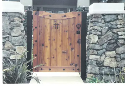 Wood pedestrian gate with iron studs between stone pillars