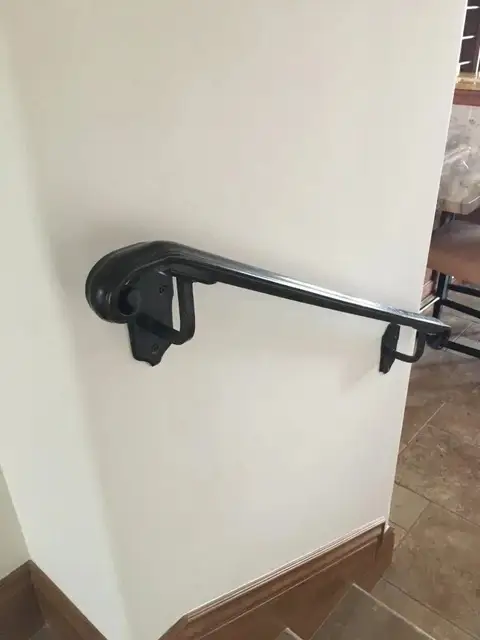 Close-up of a wall-mounted handrail with a scrolled return