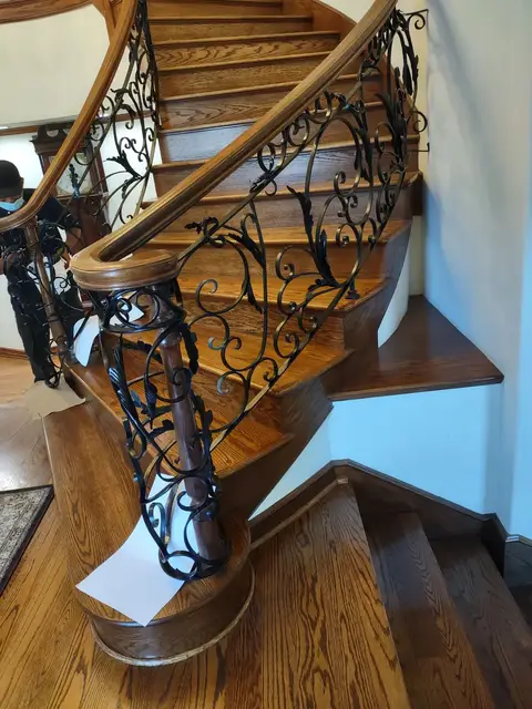 Winding wooden staircase with an ornate scrollwork railing