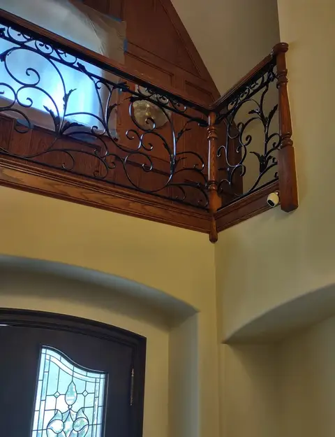 Corner mezzanine railing with vine scrollwork and wood trim