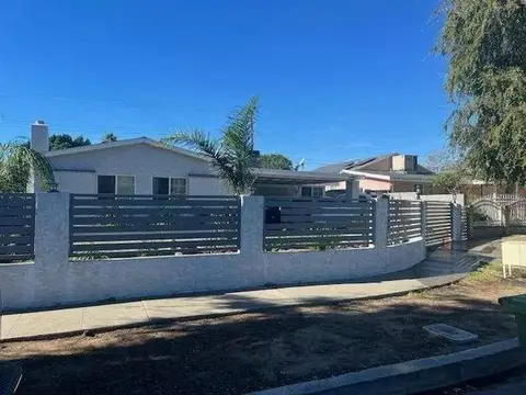 Curved front yard fence with horizontal slats on a block wall