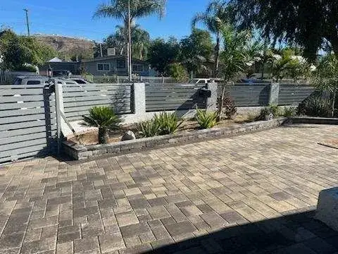 Paver driveway with gray horizontal slat fencing
