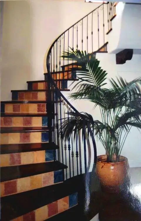 Tiled staircase with a curved vertical-bar iron railing
