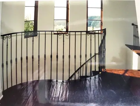 Landing railing with vertical bars and ball details over a wood floor
