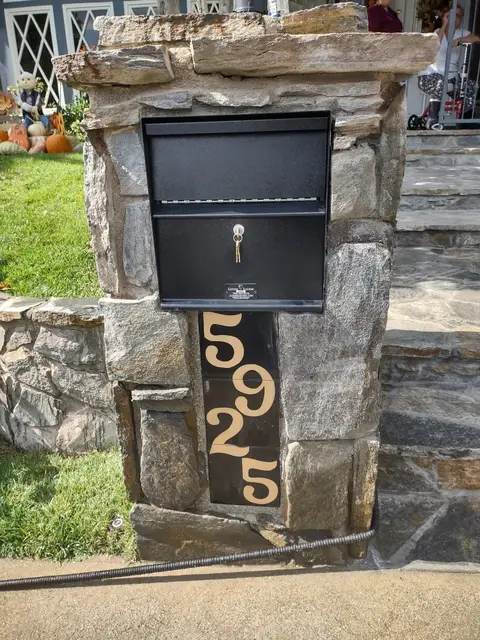 Stone mailbox pillar with hand-forged iron address numbers