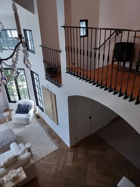 Second-floor landing railings with straight bars in a two-story foyer