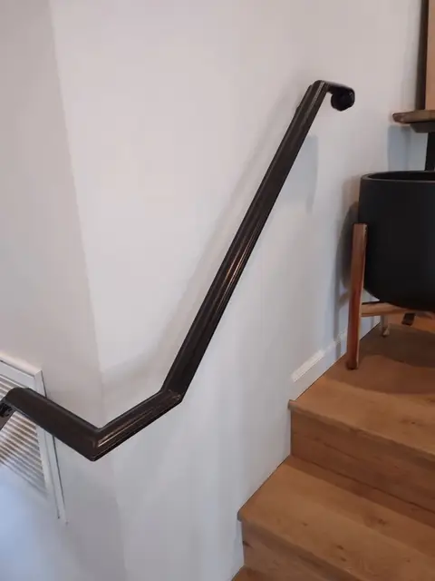 Wall-mounted iron handrail on wooden steps