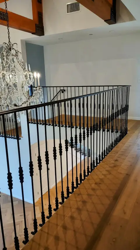 Landing railing with straight bars along a wood-floored walkway