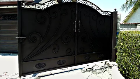 Solid black privacy driveway gates with embossed swirl designs