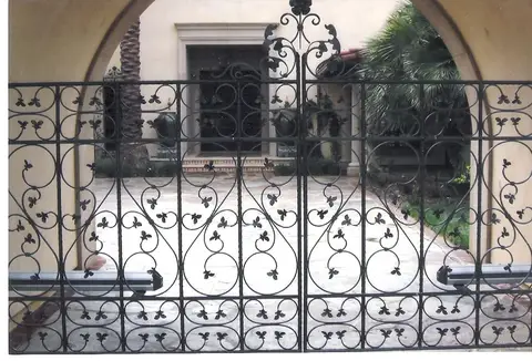 Double courtyard gates with all-over scrollwork and fleur accents