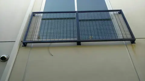 Modern grid-pattern window guard in black steel
