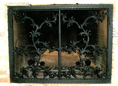 Fireplace screen with vine scrollwork over black mesh doors
