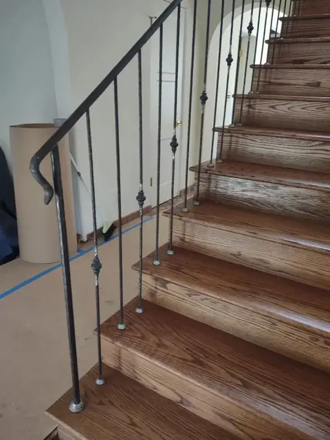 Simple modern stair railing with slim bars on wood stairs