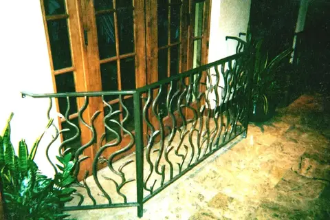Patio railing with flowing wavy bars beside French doors