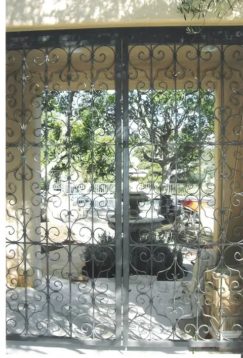 Scrollwork iron security doors over glass patio doors