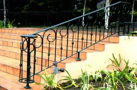 Outdoor stair railing with scroll details on tiled steps