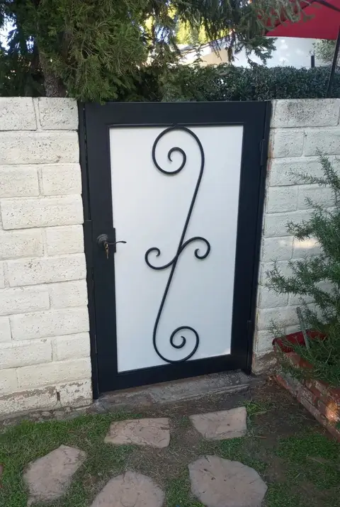 Modern side gate with a frosted panel and a single bold scroll