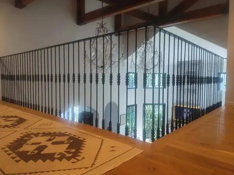 Wide landing railing with straight bars beneath exposed beams