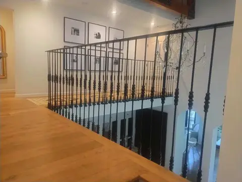 Landing railing with straight bars over a light wood floor