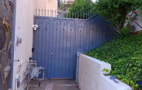 Blue-gray side gate with a matching sloped fence panel