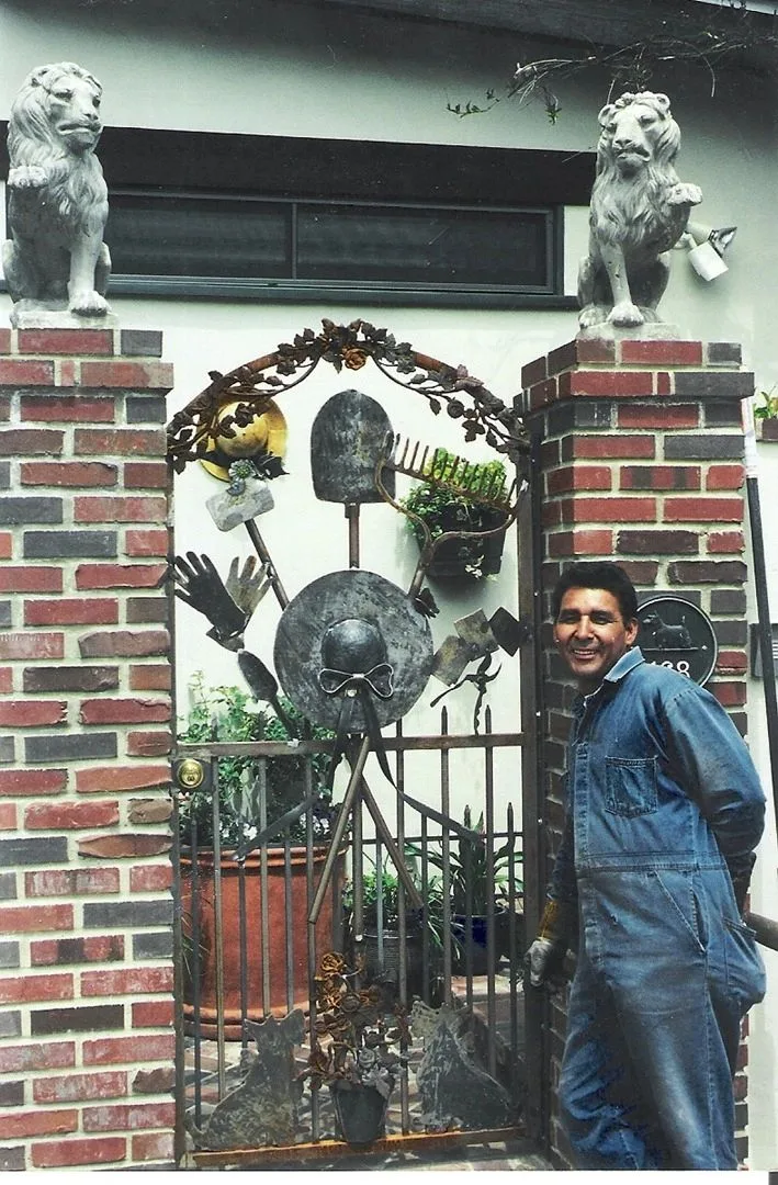Art Murillo beside a custom iron gate